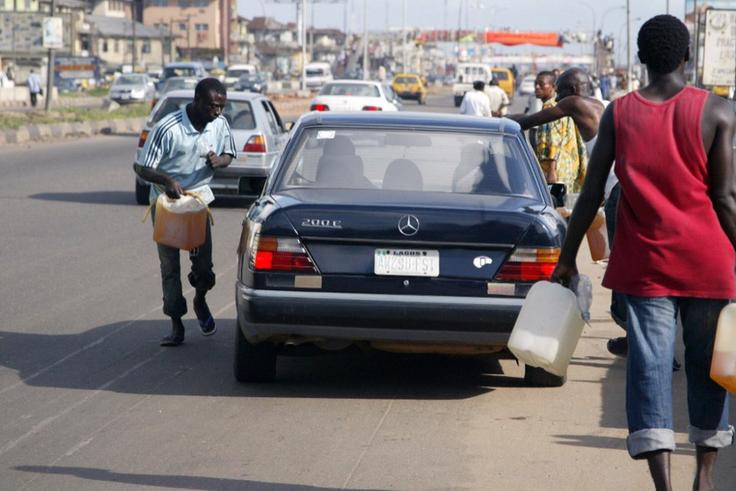 Black market fuel vendors tries to sell fuel to a motorist on Lagos-Ikorodu highway 17 June 2007. [Getty Images]