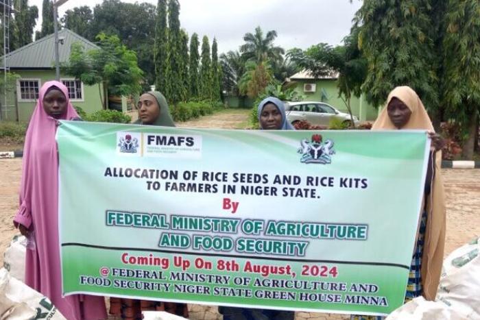 Some of the women farmers in Niger on Friday who benefitted from the Federal Government’s free rice seeds and rice kits displaying the items with a banner [NAN]