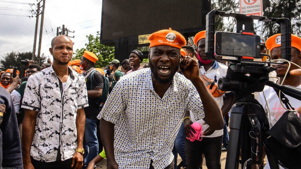 A Member of the Revolution Now protesters reacts to a live streaming phone in Lagos Nigeria while demanding for better governance for the present administration, during a protest in Lagos Nigeria to mark the 60th Independence Day anniversary on October...