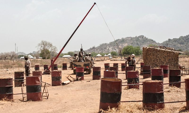 A heavily armed military convoy of the Nigerian Army pass through a checkpoint. [Getty Images]