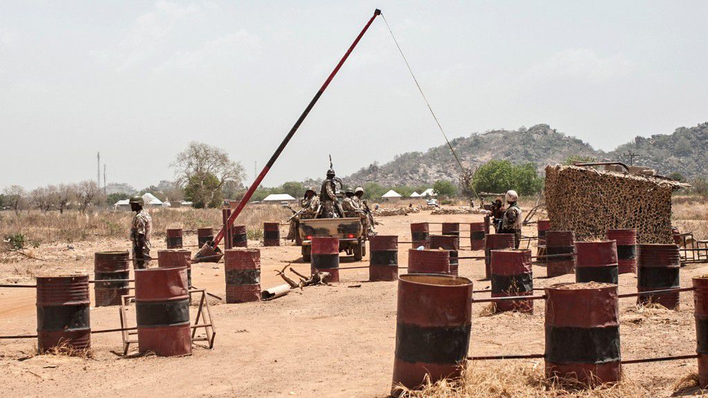 A heavily armed military convoy of the Nigerian Army pass through a checkpoint. [Getty Images]