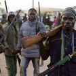 In this Wednesday Nov. 25, 2014 file photo, hunters gather during a meeting in Yolo, Nigeria. Thousands of Nigerian hunters, armed with charmed amulets and intimate knowledge of harsh terrain, are preparing an offensive against the Boko Haram extremist...