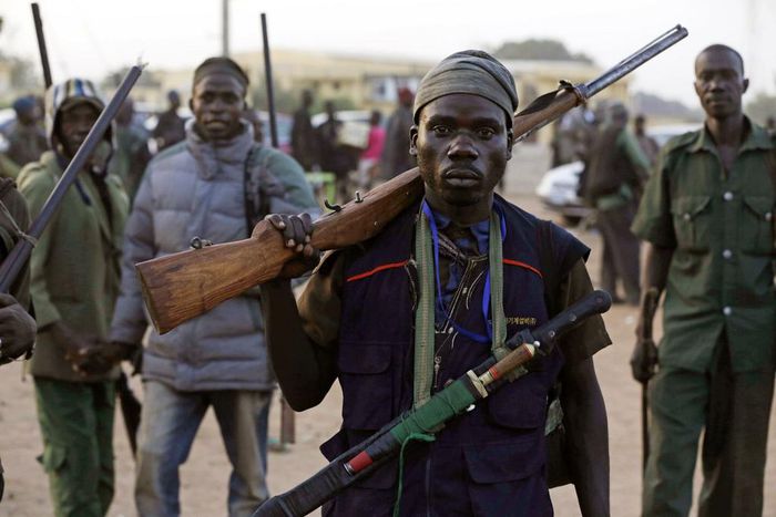 In this Wednesday Nov. 25, 2014 file photo, hunters gather during a meeting in Yolo, Nigeria. Thousands of Nigerian hunters, armed with charmed amulets and intimate knowledge of harsh terrain, are preparing an offensive against the Boko Haram extremist...