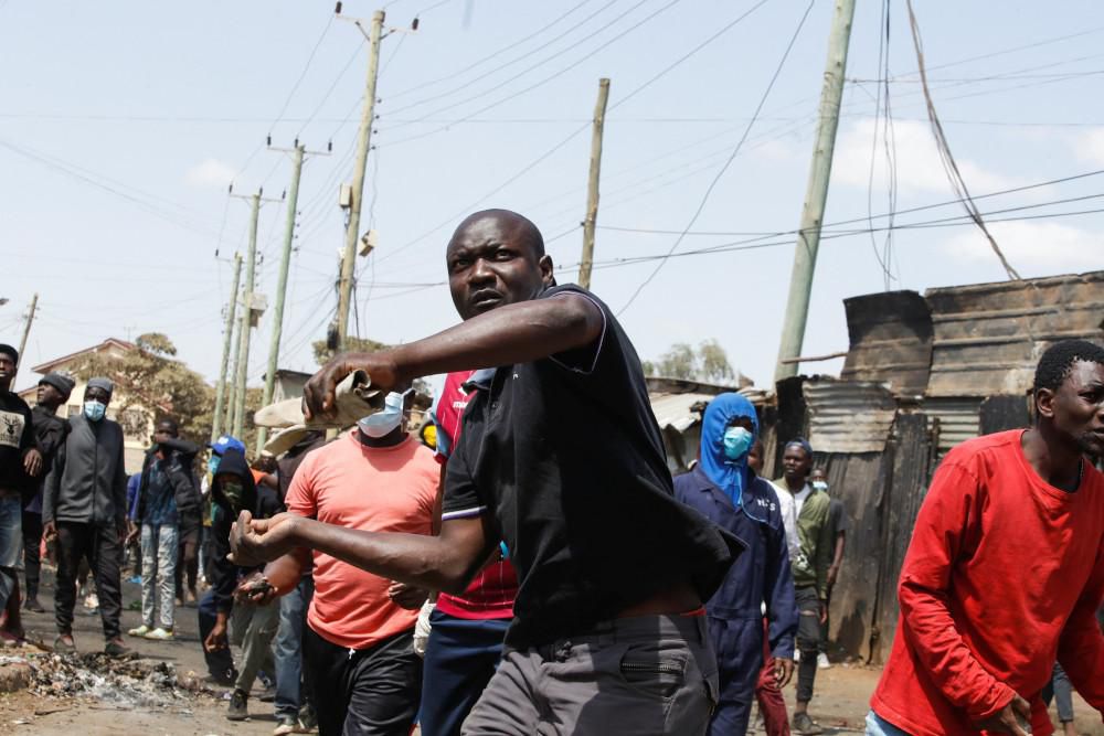 A Kenyan porter throwing a missile at anti-riot police officers