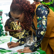 Mrs Uju Kennedy-Ohanenye, Minister of Women Affairs, signing a condolence register at the National Council of Women Societies (NCWS) headquarters on Wednesday in Abuja.