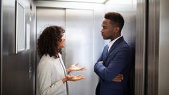 Black couple inside an elevator [Adobe Stock]