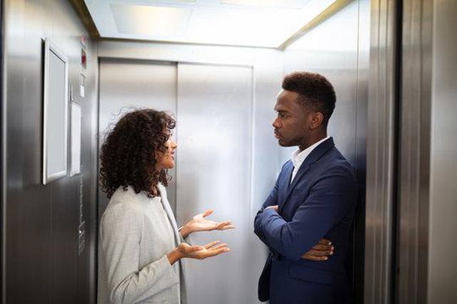 Black couple inside an elevator [Adobe Stock]