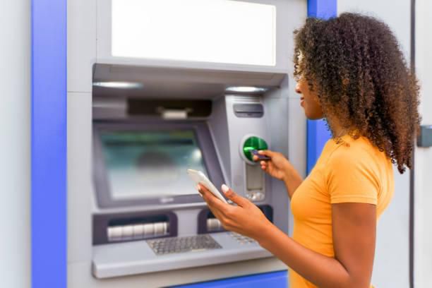 Black woman at an ATM [iStock]