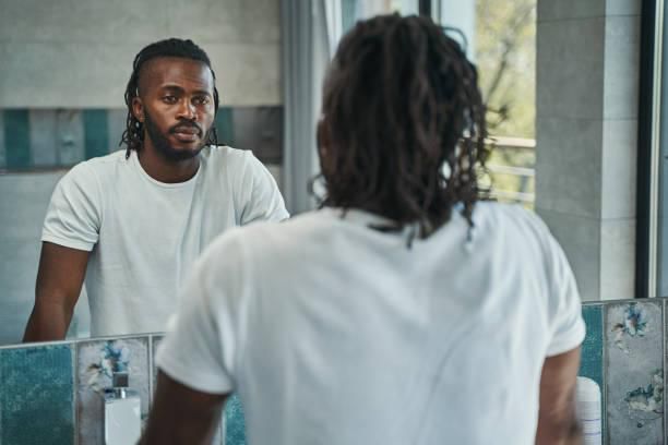 Black man looking in the mirror [iStock]