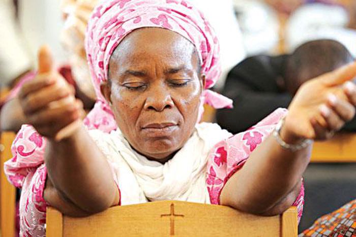 A woman praying on her knees [The Guardian Nigeria]