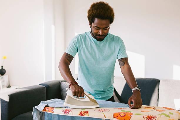 A photo of a man ironing clothes
