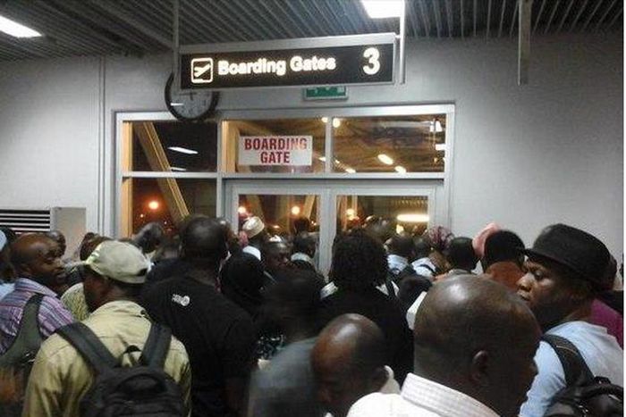 Passengers at the Nnamdi Azikwe International Airport, who were scheduled to travel to Ibadan by Arik Air but were left stranded for hours, block boarding gate at Abuja Airport January 30, 2015, in protest.