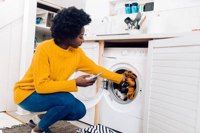 Black woman doing laundry [iStock]
