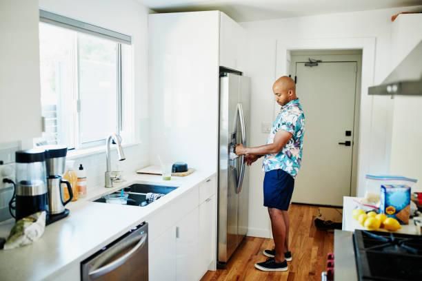 A man trying to move a fridge