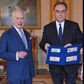 King Charles III (left) is presented with the first bank notes featuring his portrait from the Bank of England Governor Andrew Bailey and Sarah John, the Bank of England's Chief Cashier, at Buckingham Palace, April 9, 2024 in London, England. [Getty Im...