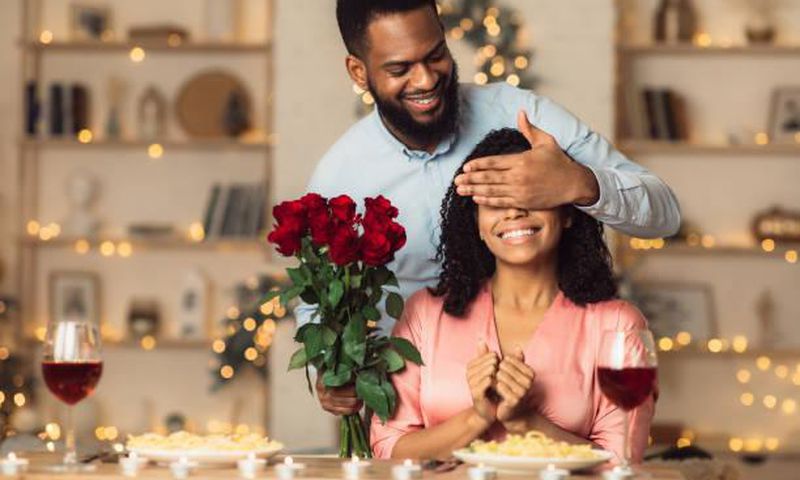 A romantic man giving her woman a flower
