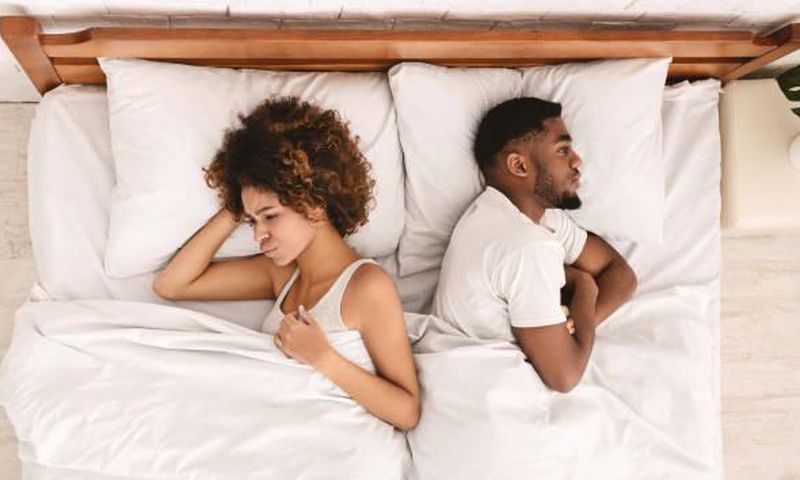Frustrated Black couple in bed [iStock]