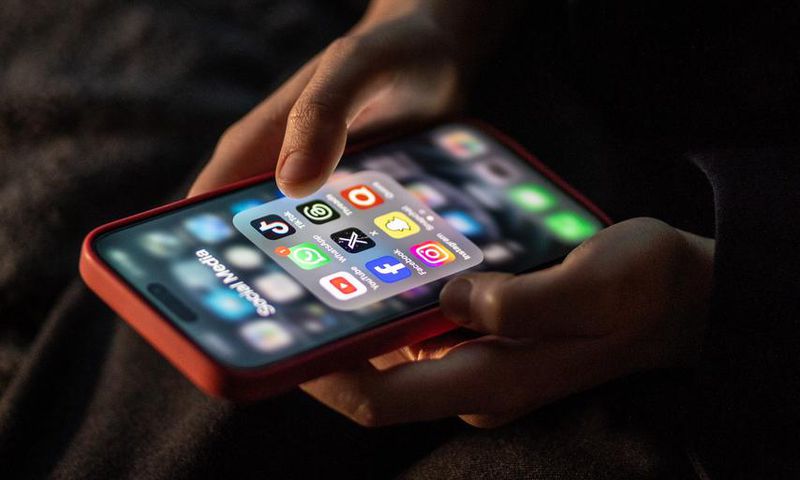 iPhone screen showing various social media apps including TikTok, Facebook and X.Matt Cardy