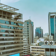 An AI-generated image of urban landscape in Nairobi, Kenya featuring modern high-rise buildings with visible air conditioning vents The scene depicts a clear sky and bustling