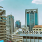 An AI-generated image of urban landscape in Nairobi, Kenya featuring modern high-rise buildings with visible air conditioning vents The scene depicts a clear sky and bustling