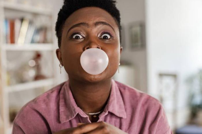 Black woman chewing gum [Adobe Stock]