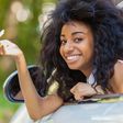 Young lady sitting in a car and holding the car keys