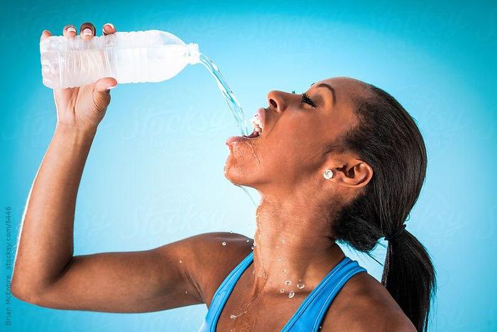 Sports woman drinking water