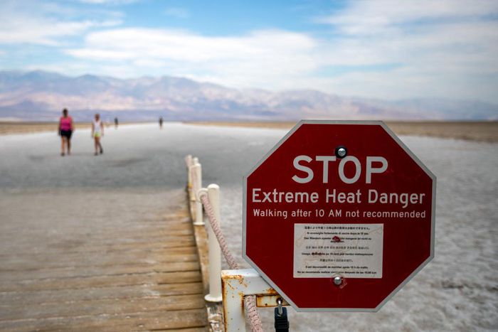 Some photos from over the weekend give context to the danger of visiting Death Valley. This image shows tourists roaming the arid plains behind an "Extreme Heat Danger" sign warning people not to walk through the area after 10 a.m.