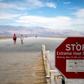 Some photos from over the weekend give context to the danger of visiting Death Valley. This image shows tourists roaming the arid plains behind an "Extreme Heat Danger" sign warning people not to walk through the area after 10 a.m.