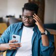A man looking at his phone worried