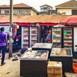 A scene in a Lagos suburb captures a Nigerian frozen food vendor at her vibrant outlet. [DALL-E]