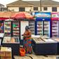 A scene in a Lagos suburb captures a Nigerian frozen food vendor at her vibrant outlet. [DALL-E]