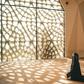 Woman praying in a mosque with openwork windows {image Credit: Hatice Baran]