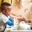 A boy in the kitchen doing the dishes [iStock]