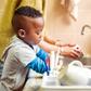 A boy in the kitchen doing the dishes [iStock]