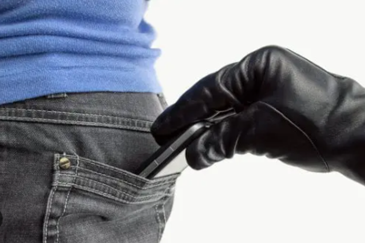 A thief stealing a phone [Daily Post Nigeria]