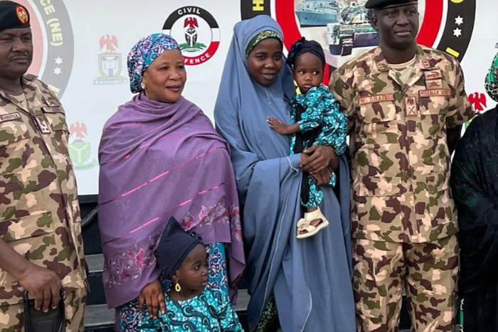 Lydia Simon in the middle carrying one of her kids.