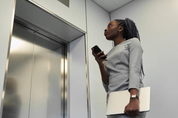 Black woman waiting for an elevator [iStock]