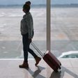 Black woman with suitcase at the airport [iStock]