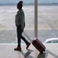 Black woman with suitcase at the airport [iStock]