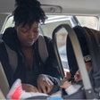 Mom puts her infant baby into a car seat [iStock]