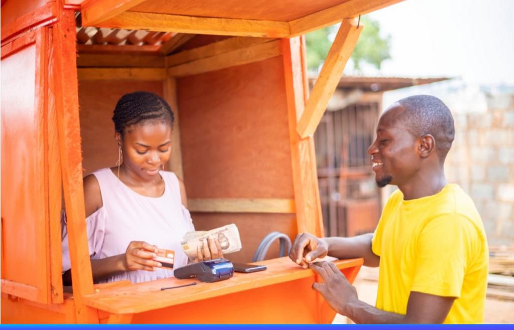 A POS Agent giving cash to a customer. [Bani blog]