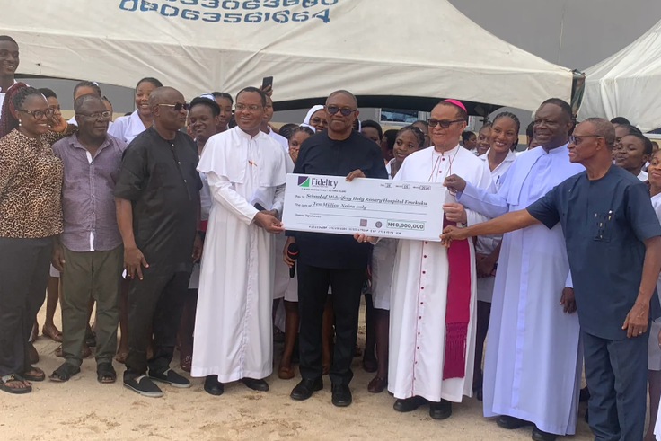 The LP Presidential Candidate in the 2023 General Elections, Mr Peter Obi, sandwiched by two priests, while presenting a cheque for N10 million donation to the Holy Rosary College of Nursing, Emekuku, Owerri, on Saturday [NAN]