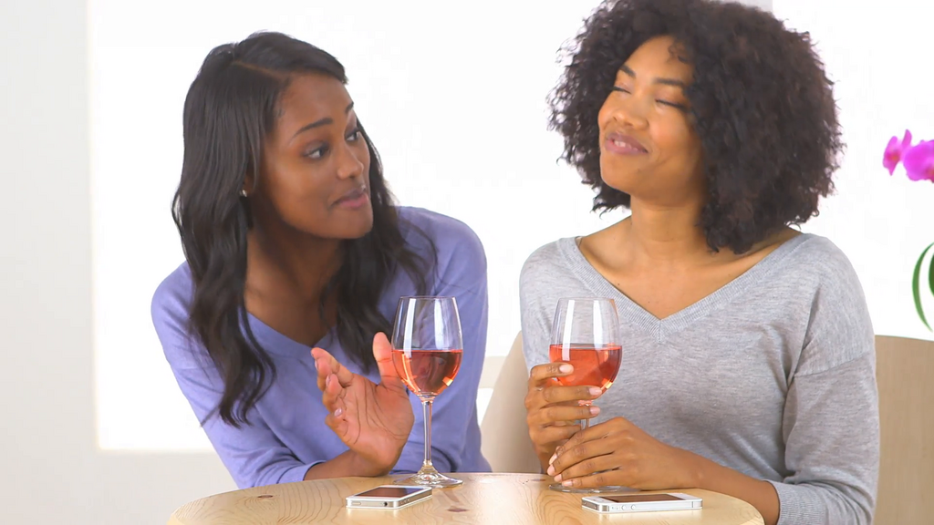 Friends having a chat over a bottle of wine [Credit: Video Blocks]