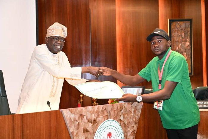 President Bola Tinubu presenting a cheque to one of the beneficiaries on Wednesday at the State House [NAN]