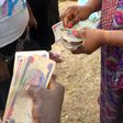 Women collecting money [Premium Times Nigeria]