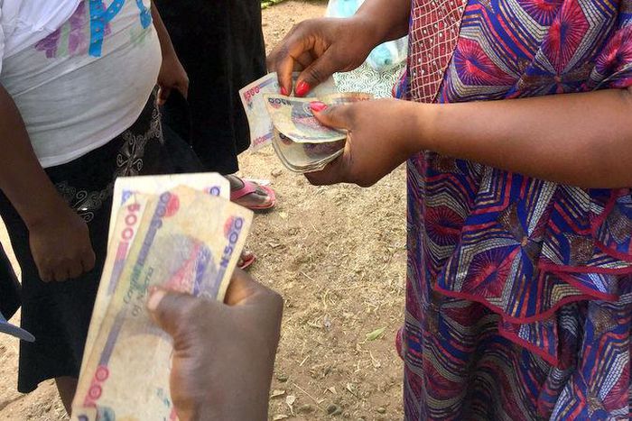 Women collecting money [Premium Times Nigeria]