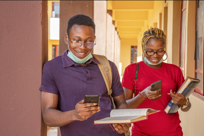 Students pressing their phones [Techpoint Africa]