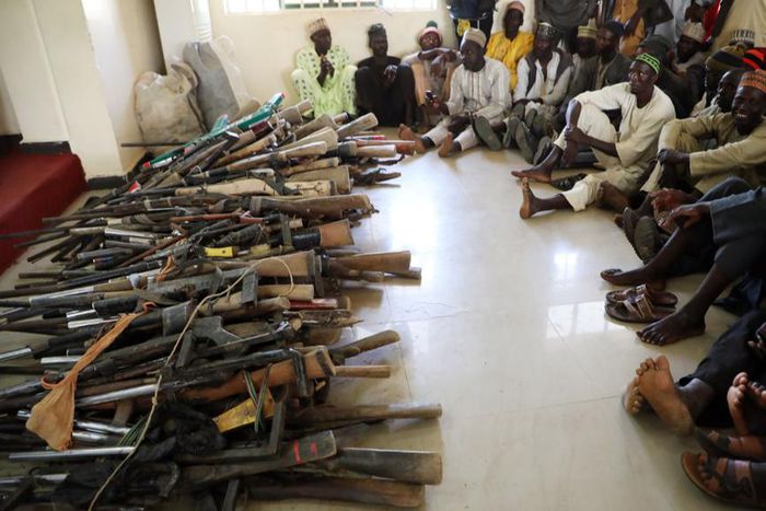 Members of the Yansakai vigilante group sit inside an auditorium at the Zamfara State Government house as their members surrendered more than 500 guns. [Getty Images]