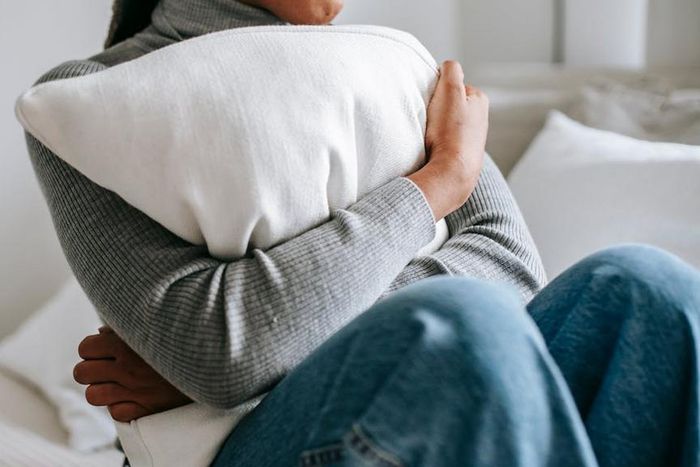Unrecognisable woman embracing a pillow in a bedroom [Image Credit: Alex Green]